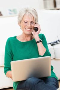 woman speaking on a frontier landline while using her laptop