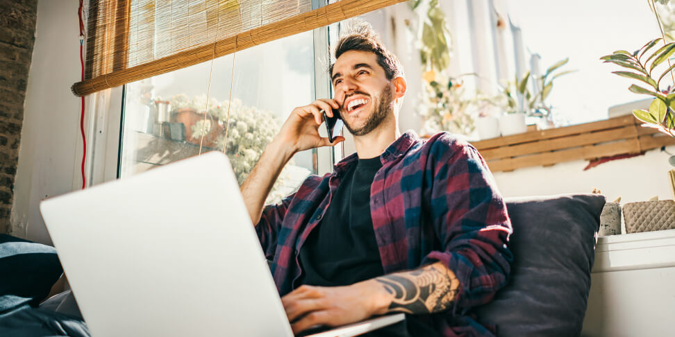 Home Phone man in apartment talking on laptop