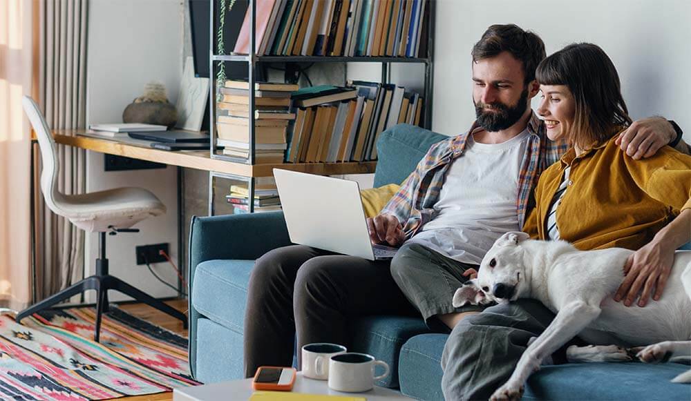 couple on laptop living room with dog_mob